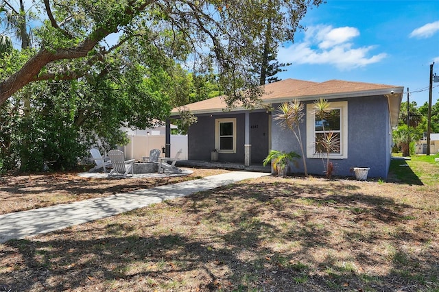 4542 19th Ave S, Saint Petersburg, FL 33711 - view of front facade with an outdoor fire pit, stucco siding, and fence