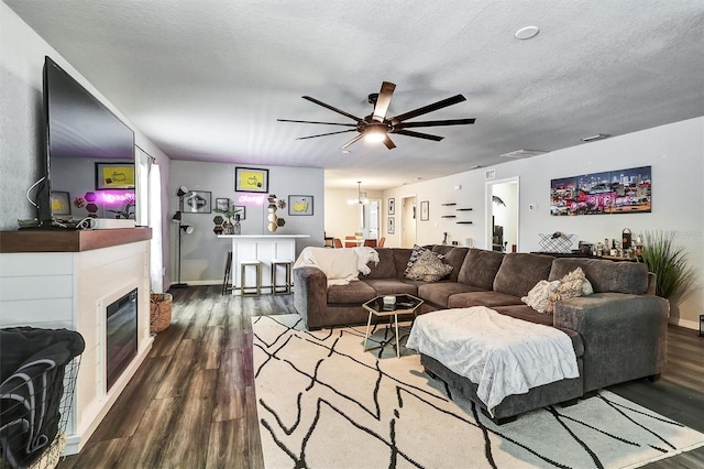 4542 19th Ave S, Saint Petersburg, FL 33711 - living room with wood finished floors, a textured ceiling, ceiling fan, baseboards, and a glass covered fireplace