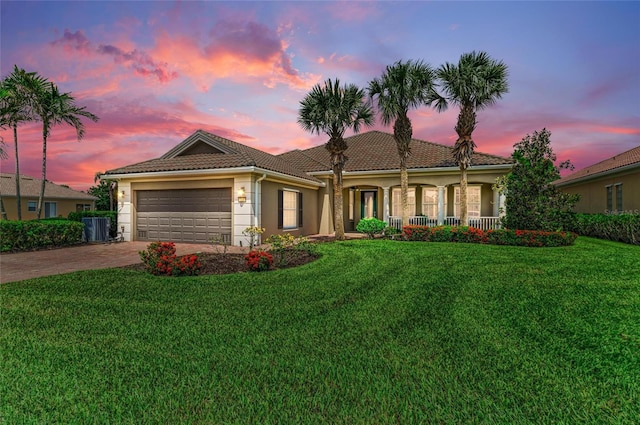 13167 Fernando St, Venice, FL 34293 - view of front of property with driveway, a garage, a front lawn, central AC, and stucco siding