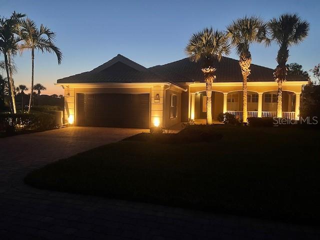 13167 Fernando St, Venice, FL 34293 - ranch-style home with an attached garage, concrete driveway, and a porch