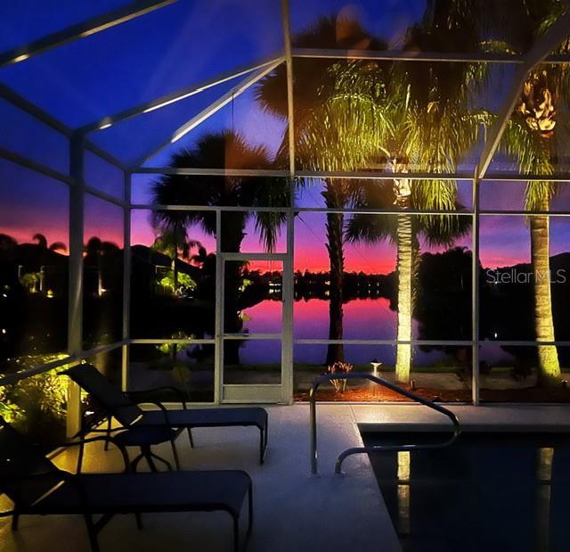 13167 Fernando St, Venice, FL 34293 - view of patio / terrace with glass enclosure, an outdoor pool, and a water view