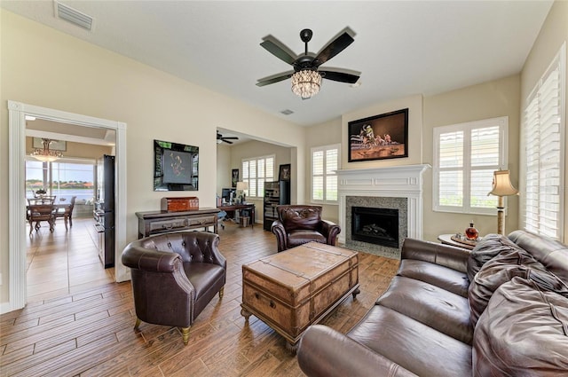 13167 Fernando St, Venice, FL 34293 - living room with ceiling fan, a fireplace with flush hearth, wood finished floors, and baseboards