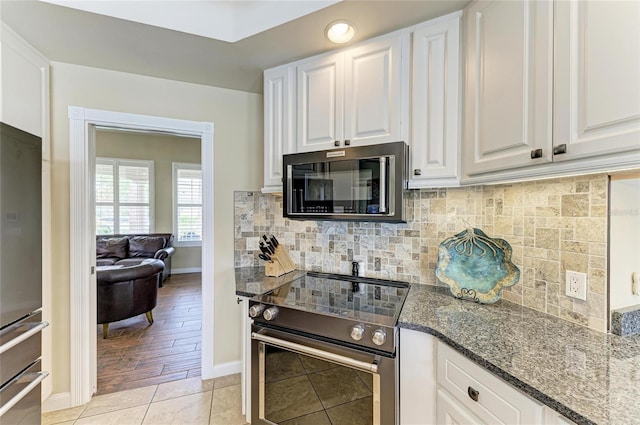 13167 Fernando St, Venice, FL 34293 - kitchen featuring electric range, baseboards, refrigerator, white cabinets, and backsplash