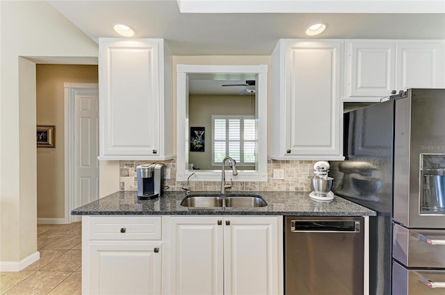 13167 Fernando St, Venice, FL 34293 - kitchen featuring a sink, appliances with stainless steel finishes, dark stone countertops, decorative backsplash, and white cabinets