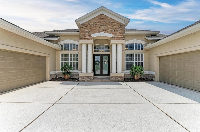 8103 Snowy Egret Pl, Bradenton, FL 34202 - entrance to property featuring french doors, stone siding, stucco siding, and concrete driveway