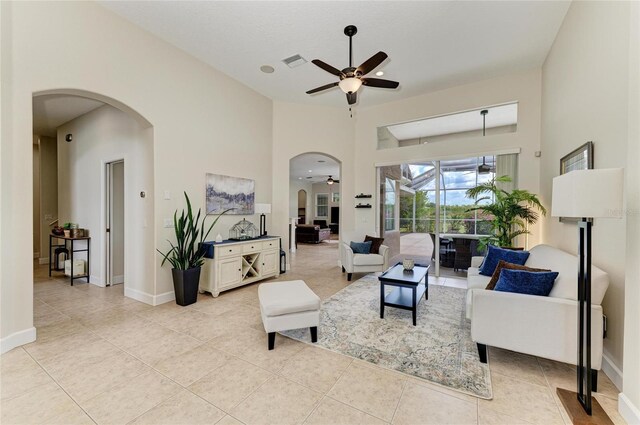 8103 Snowy Egret Pl, Bradenton, FL 34202 - living area featuring arched walkways, a ceiling fan, light tile patterned flooring, and baseboards