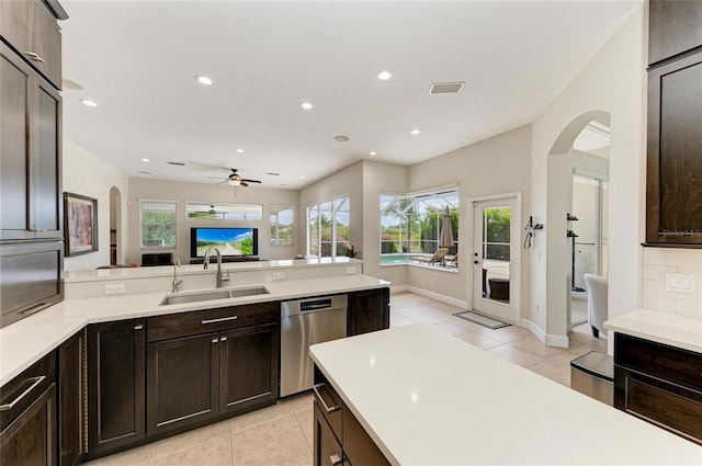 8103 Snowy Egret Pl, Bradenton, FL 34202 - kitchen featuring a sink, stainless steel dishwasher, light tile patterned floors, arched walkways, and recessed lighting