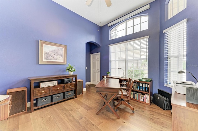 8103 Snowy Egret Pl, Bradenton, FL 34202 - office area featuring arched walkways, wood finished floors, a towering ceiling, ceiling fan, and baseboards