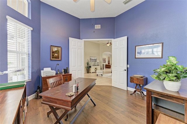 8103 Snowy Egret Pl, Bradenton, FL 34202 - office with ceiling fan, arched walkways, a towering ceiling, wood finished floors, and baseboards