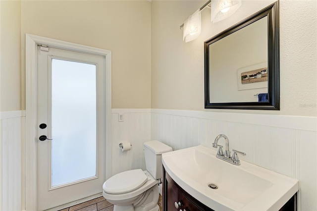8103 Snowy Egret Pl, Bradenton, FL 34202 - bathroom with a wainscoted wall, vanity, toilet, and plenty of natural light