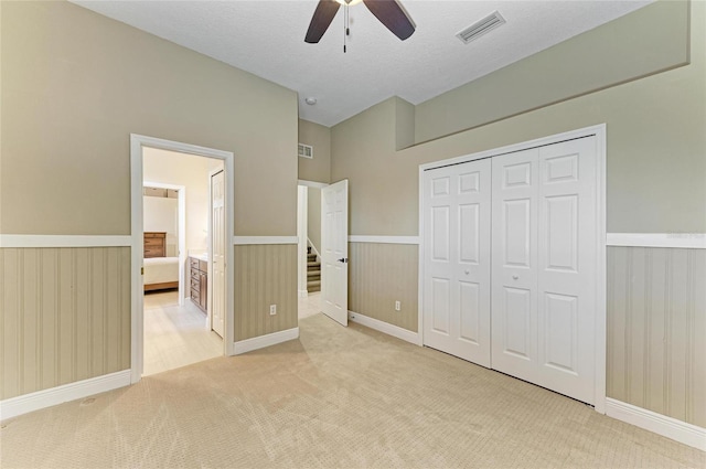 8103 Snowy Egret Pl, Bradenton, FL 34202 - unfurnished bedroom with carpet flooring, a closet, a ceiling fan, a wainscoted wall, and ensuite bathroom