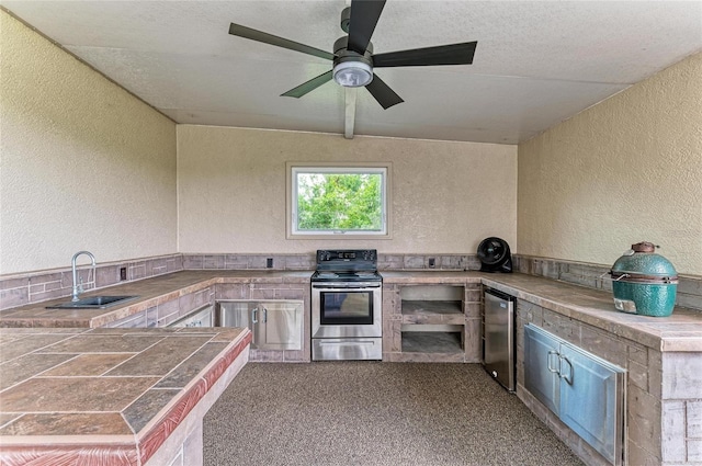 8103 Snowy Egret Pl, Bradenton, FL 34202 - kitchen with stainless steel electric stove, a sink, a textured wall, fridge, and carpet