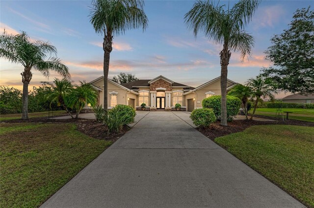 8103 Snowy Egret Pl, Bradenton, FL 34202 - mediterranean / spanish-style house with an attached garage, driveway, a front yard, stucco siding, and french doors