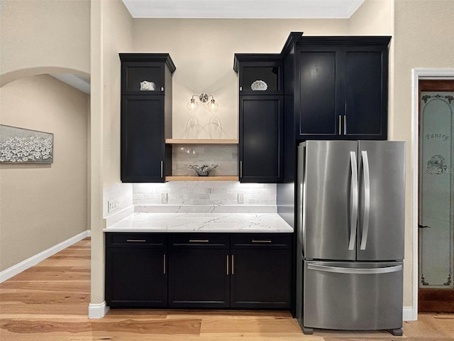 6567 Eagle Ridge Way, Lakeland, FL 33813 - kitchen featuring freestanding refrigerator, dark cabinets, tasteful backsplash, open shelves, and arched walkways