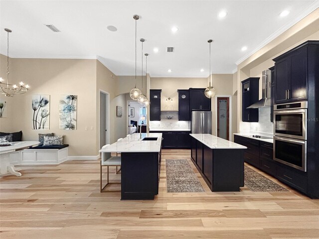 6567 Eagle Ridge Way, Lakeland, FL 33813 - kitchen featuring appliances with stainless steel finishes, a center island with sink, ornamental molding, a chandelier, and light wood-type flooring
