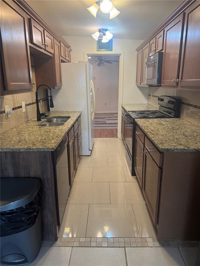 kitchen featuring a sink, dark stone counters, electric range, ceiling fan, and dishwasher