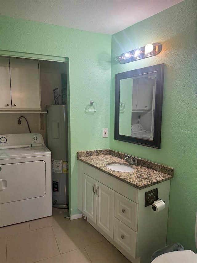 bathroom with tile patterned flooring, a textured wall, electric water heater, vanity, and washer / clothes dryer