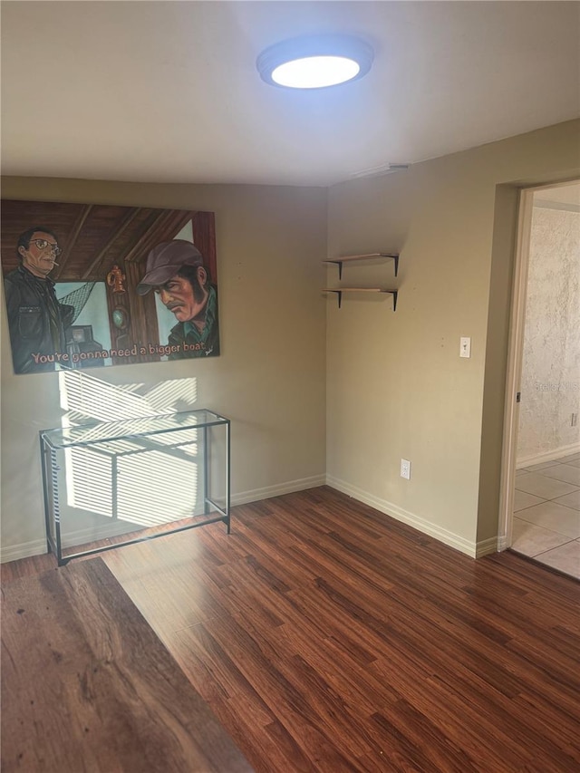 unfurnished room featuring wood finished floors and baseboards