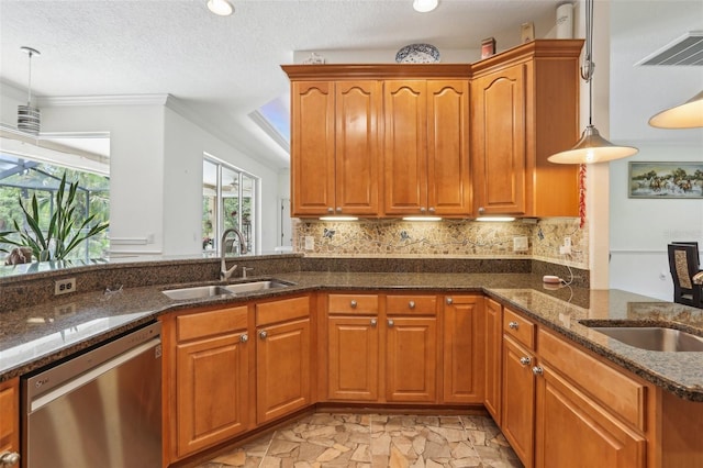 kitchen with a peninsula, a sink, stainless steel dishwasher, and dark stone counters