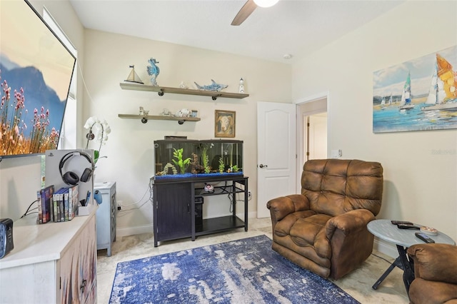 living area with ceiling fan and baseboards