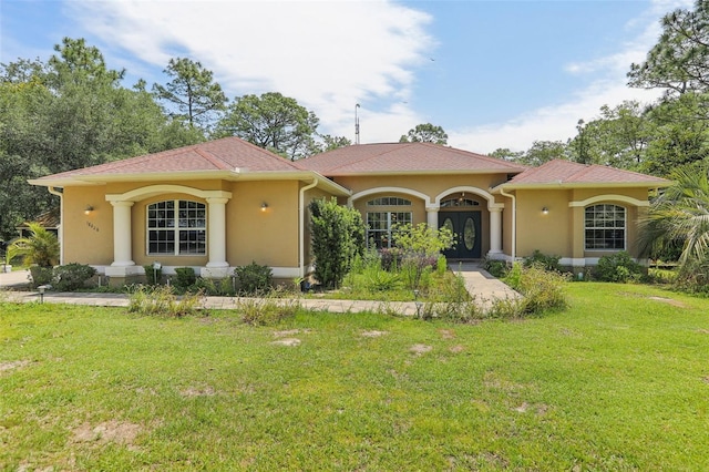 rear view of house featuring stucco siding and a lawn