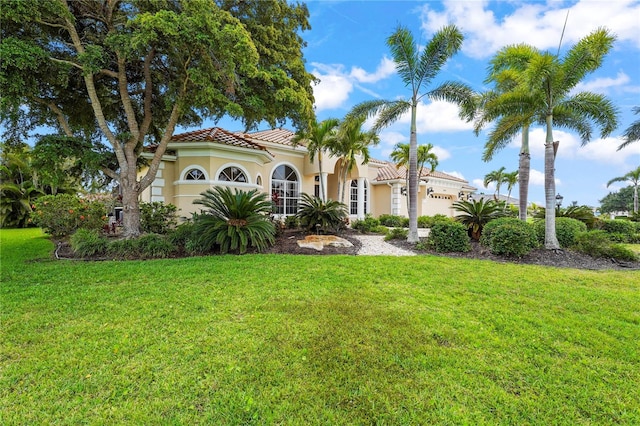 6143 9th Avenue Cir NE, Bradenton, FL 34212 - mediterranean / spanish home featuring a tiled roof, stucco siding, a garage, and a front yard