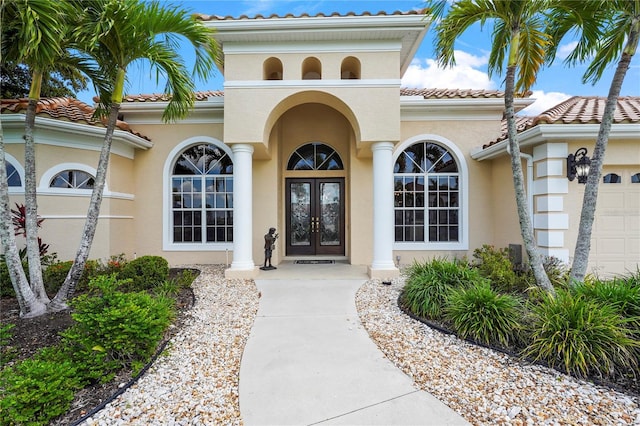 6143 9th Avenue Cir NE, Bradenton, FL 34212 - property entrance with french doors, a tiled roof, stucco siding, and a garage