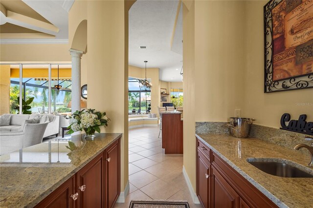6143 9th Avenue Cir NE, Bradenton, FL 34212 - bar with a sink, light tile patterned floors, decorative columns, and arched walkways