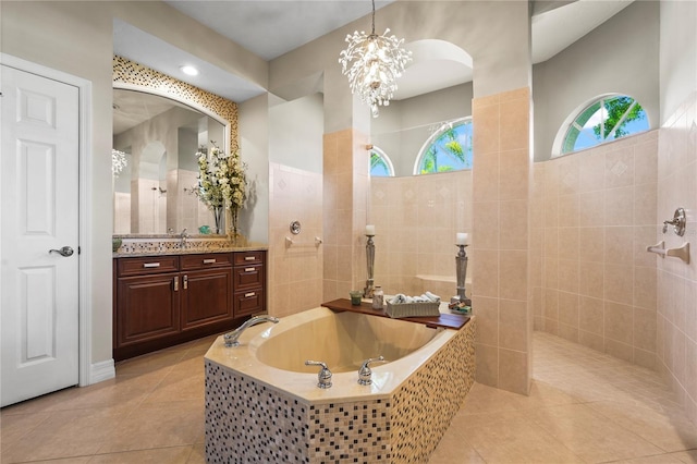 6143 9th Avenue Cir NE, Bradenton, FL 34212 - bathroom with tile patterned floors, a garden tub, walk in shower, vanity, and tile walls