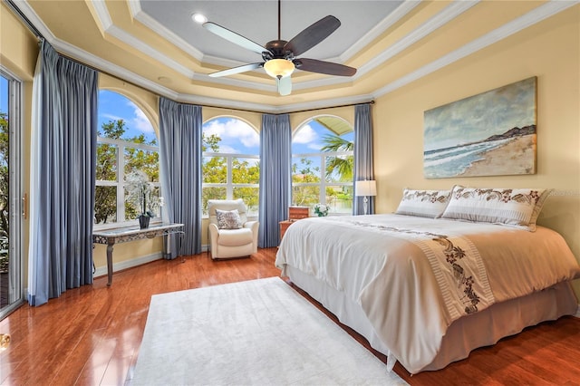 6143 9th Avenue Cir NE, Bradenton, FL 34212 - bedroom with ornamental molding, a tray ceiling, multiple windows, wood finished floors, and ceiling fan
