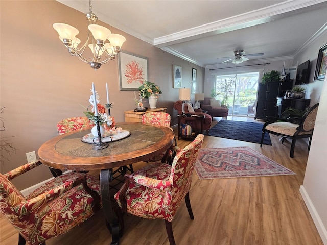 dining room with baseboards, wood finished floors, ceiling fan with notable chandelier, and ornamental molding