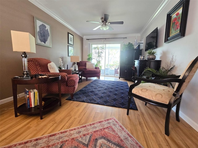 living room featuring crown molding, baseboards, wood finished floors, and a ceiling fan