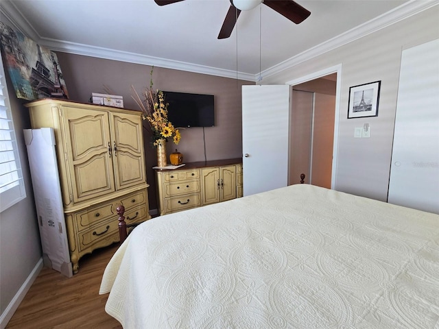 bedroom featuring crown molding, baseboards, ceiling fan, and wood finished floors