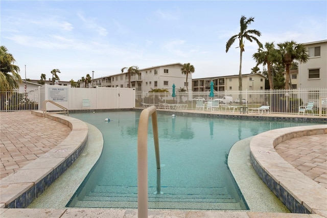 pool featuring fence and a patio area