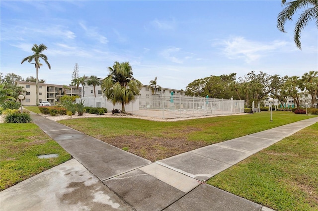 view of home's community featuring a yard, fence, and a residential view