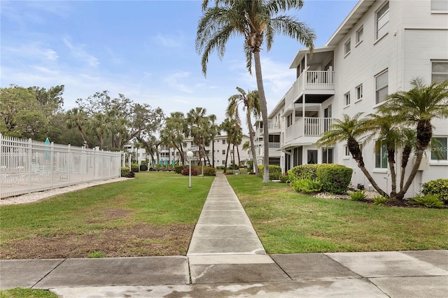 view of community featuring fence and a lawn