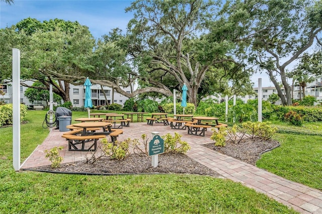 surrounding community featuring a lawn and a patio area