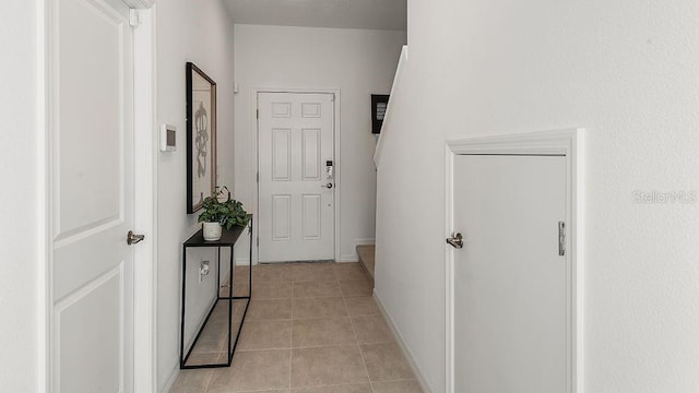 hallway with baseboards and light tile patterned flooring