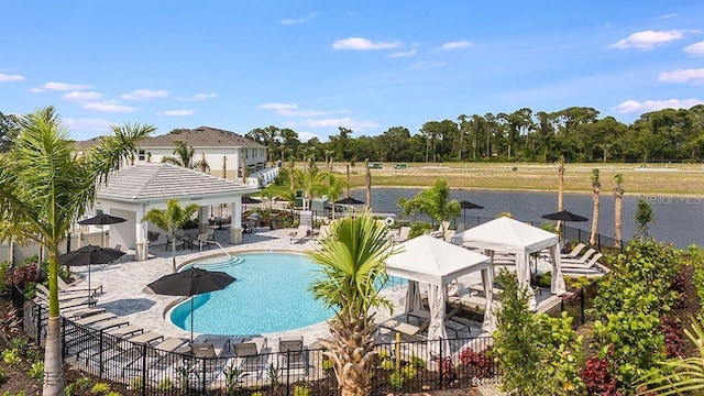 community pool with a water view, a gazebo, fence, and a patio