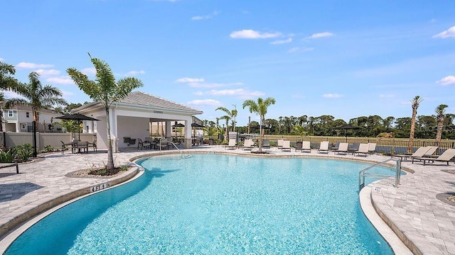 pool featuring a patio and fence