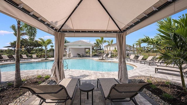pool featuring a gazebo, a patio area, and fence