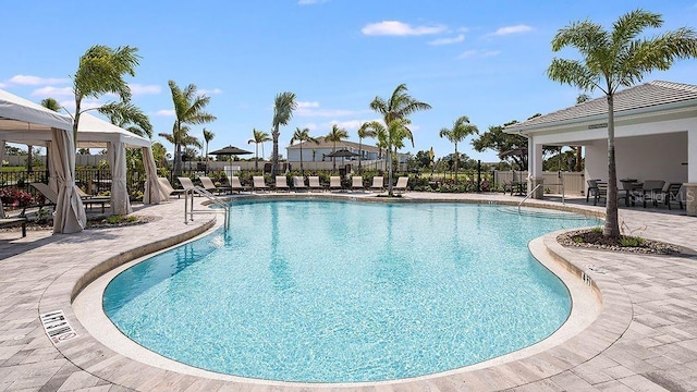 community pool featuring a gazebo, a patio area, and fence
