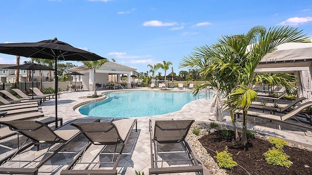 community pool with a patio and fence