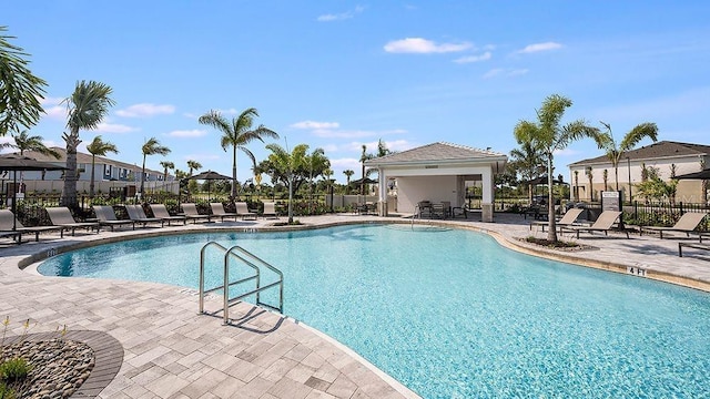 community pool with a patio and fence