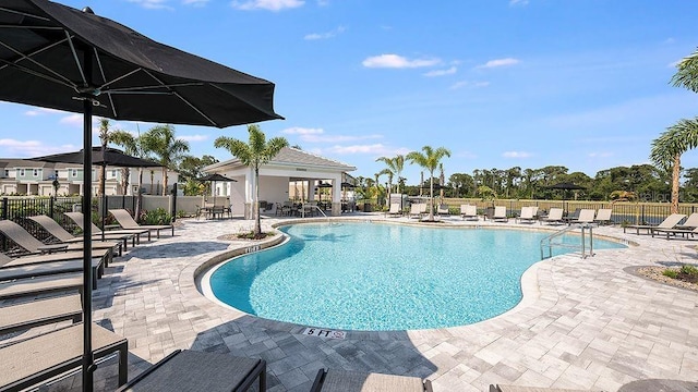 pool with a patio and fence