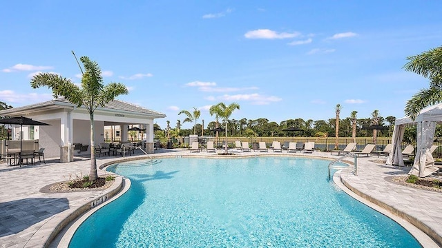 pool with a patio area and fence