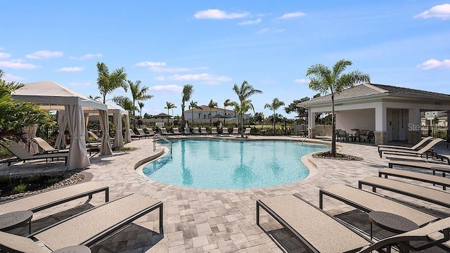 pool with a gazebo, a patio, and fence