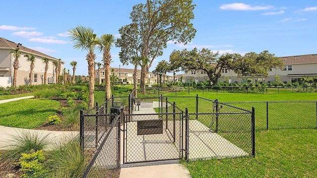 view of property's community featuring a gate, fence, a residential view, and a lawn