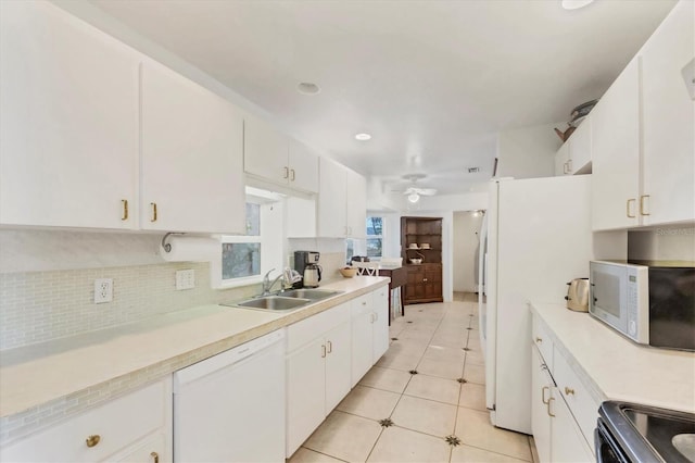 9366 Westminster Ave, Englewood, FL 34224 - kitchen with white appliances, light countertops, decorative backsplash, white cabinets, and a ceiling fan