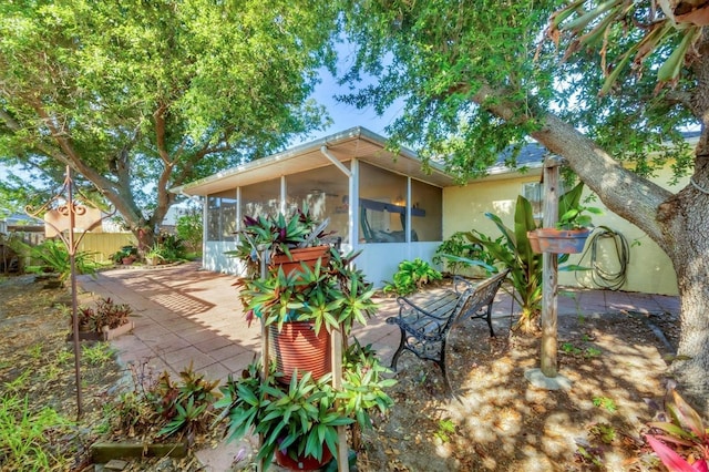 9366 Westminster Ave, Englewood, FL 34224 - view of side of home featuring a sunroom, a patio, and stucco siding